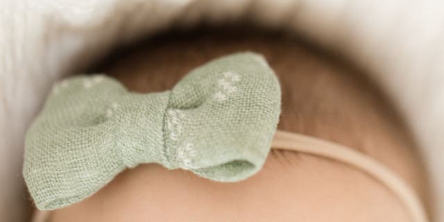 Baby girl with green hair bow