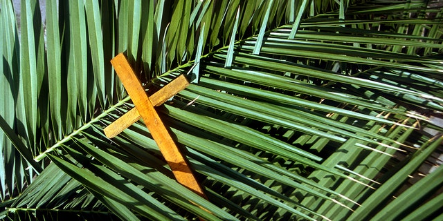 Wooden cross on palm leaves, Palm Sunday. It is during Holy Week, writes Lauren Green, "that the religious leaders looked to trap Jesus in not only violating the laws of Moses, Jewish law — but Roman law as well."