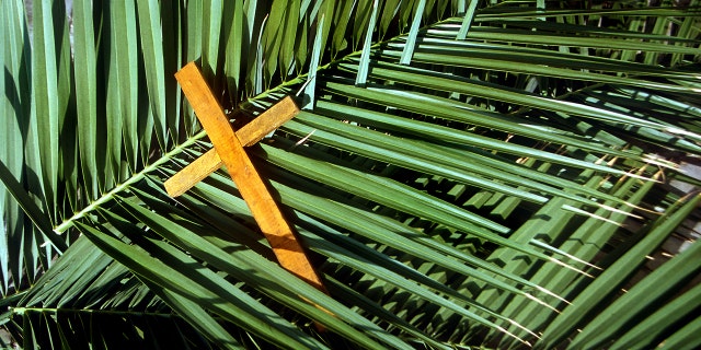 Wooden cross on palm leaves, Palm Sunday. It is during Holy Week, writes Lauren Green, "that the religious leaders looked to trap Jesus in not only violating the laws of Moses, Jewish law — but Roman law as well."