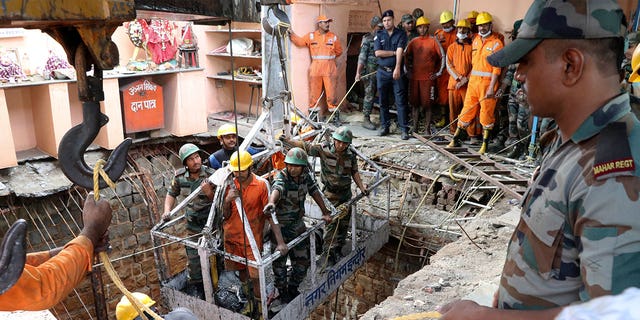 Rescue workers work at the site of a building built over the well of an ancient temple that collapsed from the weight of a large crowd attending a Hindu festival in Indore, India, on March 31, 2023. 