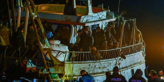 Police check a fishing boat with some 500 migrants in the southern Italian port of Crotone early Saturday. The Italian coast guard was responding to three smugglers boats carrying more than 1,300 migrants "in danger" off Italy’s southern coast.