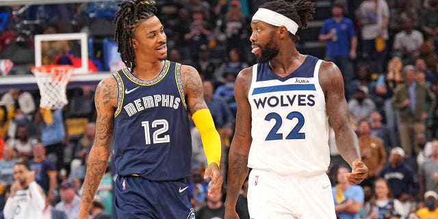 Ja Morant #12 de los Memphis Grizzlies y Patrick Beverly #22 de los Minnesota Timberwolves sonríen durante la primera entrada del Juego 5 el 26 de abril de 2022 en el FedExForum de Memphis, Tennessee.
