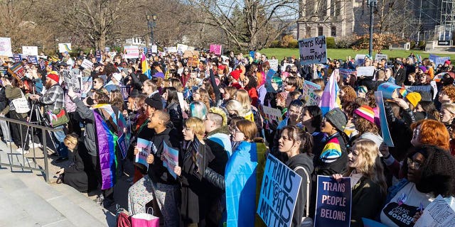 Protesters hold signs outside of the Kentucky Capitol building
