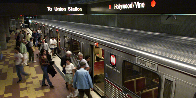 Passengers board and depart the Metro Red Line subway train at the Hollywood and Vine station in Hollywood, California.