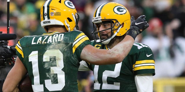 El receptor abierto de los Green Bay Packers, Allen Lazard (13), celebra con el mariscal de campo Aaron Rodgers (12) durante un partido contra los Cleveland Browns el 25 de diciembre de 2021 en Lambeau Field en Green Bay, Wisconsin. 