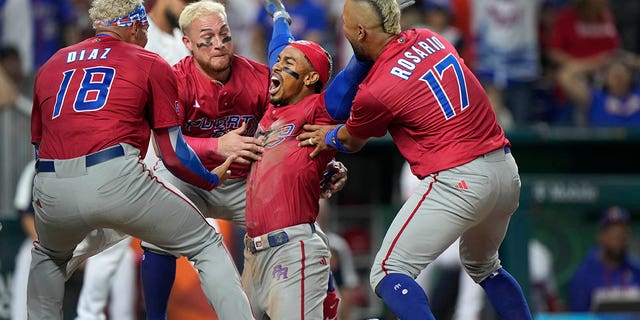 Puerto Rico's Francisco Lindor second from right, celebrates with teammates after he scored on a fielding error by Dominican Republic center fielder Julio Rodriguez during the fifth inning of a World Baseball Classic game, Wednesday, March 15, 2023, in Miami.