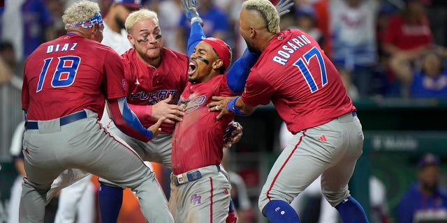 Puerto Rico's Francisco Lindor, second from right, celebrates with his teammates after he scored on a fielding error by Dominican Republic center fielder Julio Rodríguez during the fifth inning of a World Baseball Classic game on Wednesday, May 15. March 2023, in Miami.