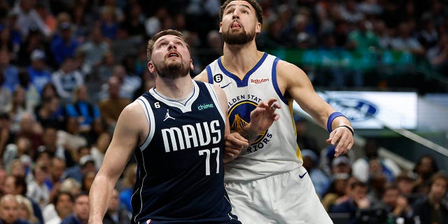 El No. 77 de los Dallas Mavericks, Luka Doncic, y el No. 11 de los Golden State Warriors, Klay Thompson, luchan por la primera mitad en el American Airlines Center el 22 de marzo de 2023 en Dallas, Texas.