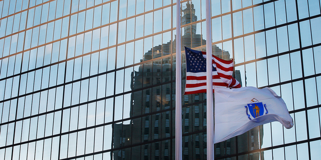 The U.S. and Massachusetts flags fly at half staff in Boston.
