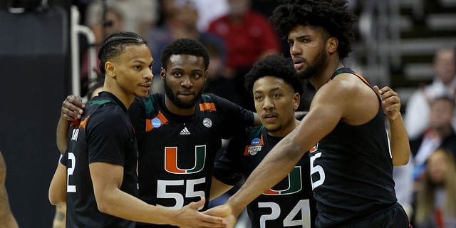   Isaiah Wong #2, Wooga Poplar #55, Nijel Pack #24 and Norchad Omier #15 of the Miami Hurricanes team up against the Houston Cougars during the first half of the Sweet 16 round of the NCAA Men's Basketball Tournament on T-Mobile Center on March 24, 2023 in Kansas City, Missouri. 