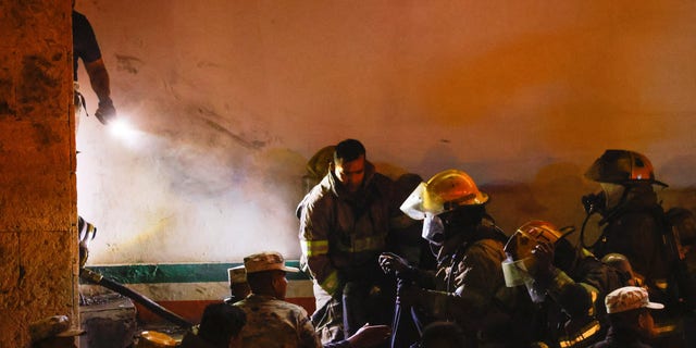Mexican authorities and firefighters remove injured migrants, mostly Venezuelans, from inside the National Migration Institute (INM) building during a fire, in Ciudad Juarez, Mexico on March 27, 2023.