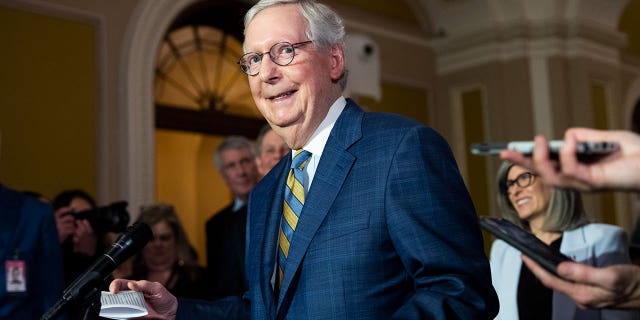 Sen. Mitch McConnell smiles as he walks through Capitol Hill
