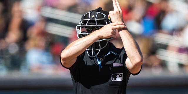 Umpire Matt Brown signals a pitch clock violation during a spring training game between the Arizona Diamondbacks and the Colorado Rockies at Salt River Fields at Talking Stick March 12, 2023, in Scottsdale, Ariz. 