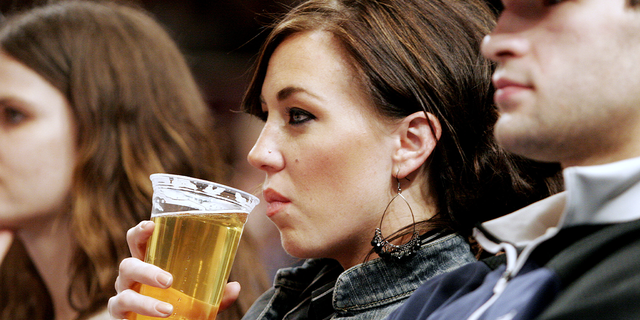 A female fan takes a drink while watching the New York Knicks take on the Philadelphia 76ers.
