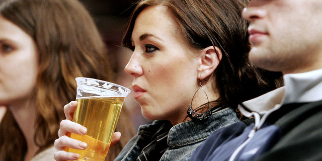 A female fan takes a drink while watching the New York Knicks take on the Philadelphia 76ers.