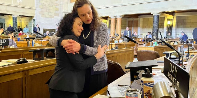 Left-wing Nebraska Sens. Jen Day and Danielle Conrad hug on the Legislature's floor as a bill banning sexual reassignment surgeries and hormone treatments for minors advances in the chamber.