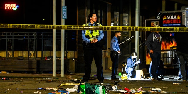 Police officers collect evidence at the scene of a shooting that occurred during the Krewe of Bacchus parade Feb. 19, 2023 in New Orleans.