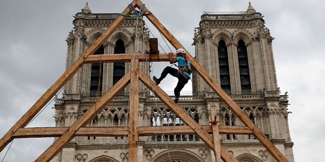 A carpenter works in front of the Notre Dame Cathedral in Paris, France, on Sept. 19, 2020. France's Notre Dame Cathedral's reconstruction is progressing enough to allow its reopening to the public at the end of next year.