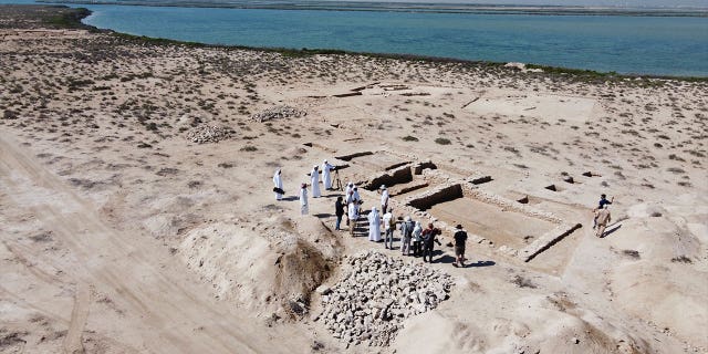 People look at ruins on Siniyah Island in Umm al-Quwain, United Arab Emirates, on March 20, 2023. Archeologists said Monday that they have found the oldest pearling town in the Persian Gulf on the island.