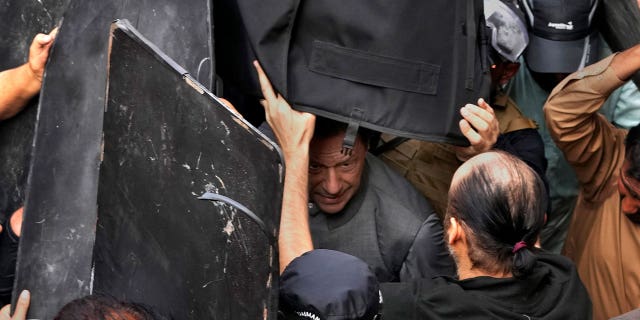 Un tribunal pakistaní concede la libertad bajo fianza al primer ministro derrocado Imran Khan en casos de terrorismo 4 El personal de seguridad lleva chalecos antibalas para proteger al ex primer ministro Imran Khan, centro, después de que compareciera ante un tribunal en Lahore, Pakistán, el 21 de marzo de 2023.