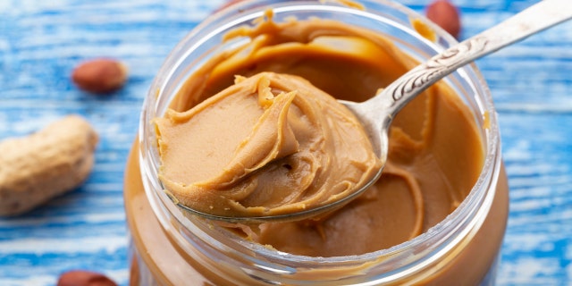 A food allergist dietitian recommends mixing two teaspoons of peanut butter with a couple of tablespoons of warm water, breast milk or formula to create a smooth texture for a baby.