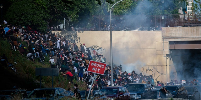 Protesters race up a hill after being shot by tear gas after a march through Center City on June 1, 2020, in Philadelphia.