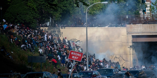 Protesters race up a hill after being shot by tear gas after a march through Center City on June 1, 2020, in Philadelphia.