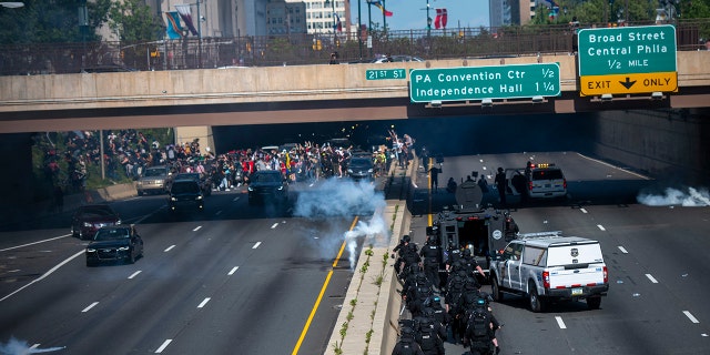 Police officers throw and shoot tear gas into a group of protesters after a march through Center City on June 1, 2020, in Philadelphia, Pennsylvania.