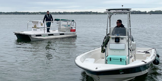 The men had jumped into the choppy water to help Orlando Ortiz's girlfriend, who believed she had to jump into the water to secure the anchor, officials said.