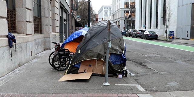 Tents and a wheelchair cover a sidewalk in downtown Portland