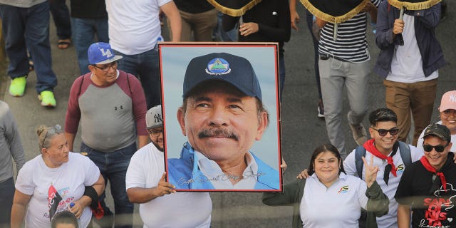 La ONU dijo que el presidente de Nicaragua está ejecutando a 40 personas y ordenando a los hospitales que no atiendan a los manifestantes 4 Un hombre sostiene un retrato del presidente Daniel Ortega durante una manifestación a favor del gobierno en Managua, Nicaragua, el 11 de febrero de 2023. Ortega ejecutó a 40 personas, según la organización de derechos humanos de las Naciones Unidas.