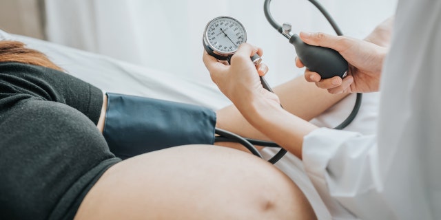 A pregnant woman is shown during an exam. Heart disease is the leading cause of maternal mortality in the U.S.