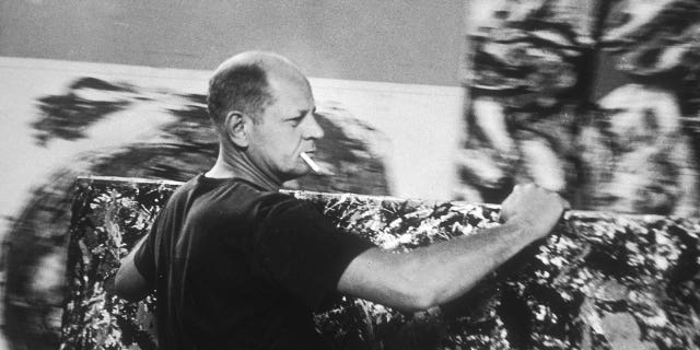 Abstract expressionist painter Jackson Pollock (1912 - 1956) moves one of his paintings in his studio in East Hampton, New York, on Aug. 23, 2953.