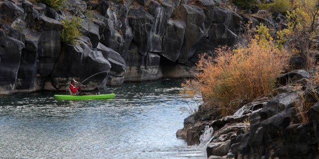 A man hooks a fish on the Snake River in Idaho Falls on Oct. 11, 2020. A federal judge on March 19, 2023, has paused the Biden administration's waterway protections in Texas and Idaho.