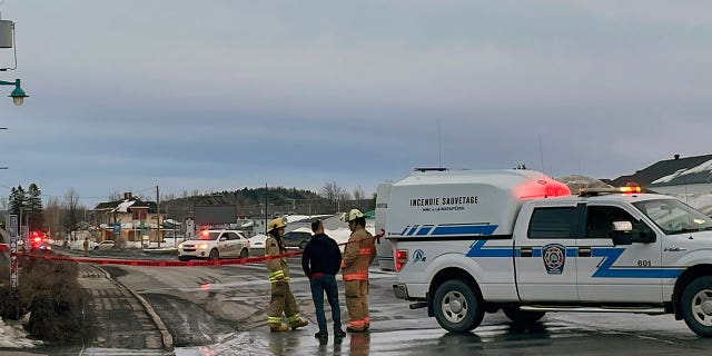 First responders work the scene where two men died after a pickup truck plowed into pedestrians who were walking beside a road in Amqui, Quebec, on March 13, 2023.