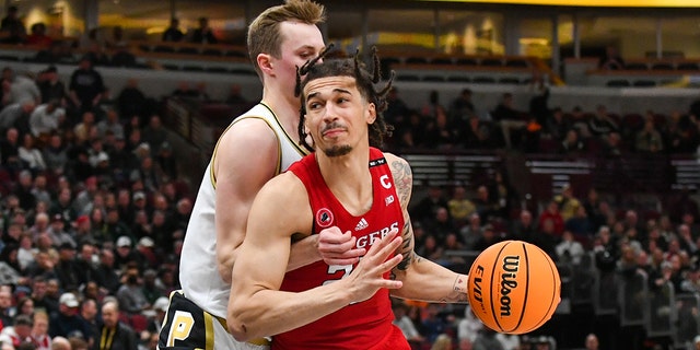 Caleb McConnell #22 of the Rutgers Scarlet Knights dribbles the ball against Fletcher Loyer #2 of the Purdue Boilermakers during the first half of a Big Ten Men's Basketball Tournament Quarterfinals game at United Center on March 10, 2023 in Chicago, Illinois.