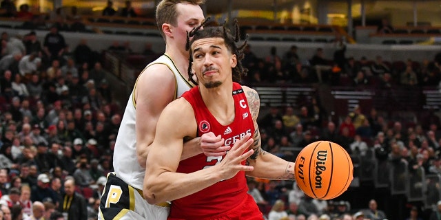 Caleb McConnell #22 of the Rutgers Scarlet Knights dribbles the ball against Fletcher Loyer #2 of the Purdue Boilermakers during the first half of a Big Ten Men's Basketball Tournament Quarterfinals game at United Center on March 10, 2023 in Chicago, Illinois.