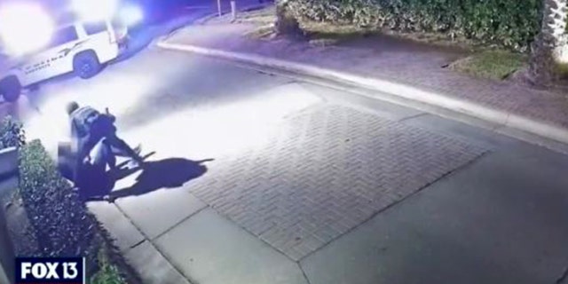 Another Sarasota police officer runs to the aid of the injured police officer.