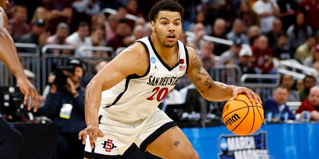 Matt Bradley #20 of the San Diego State Aztecs dribbles to the ball Jaylon Scott #21 of the Charleston Cougars during the second half in the first round of the NCAA Men's Basketball Tournament at Amway Center on March 16, 2023 in Orlando, Florida.