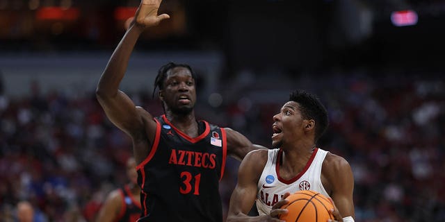 Brandon Miller #24 of the Alabama Crimson Tide controls the ball against Nathan Mensah #31 of the San Diego State Aztecs during the first half of the Sweet 16 round of the NCAA Men's Basketball Tournament at KFC YUM!  Center on March 24, 2023 in Louisville, Kentucky. 