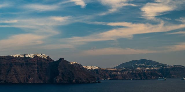 Towns sit above the cliffs of Santorini near the Aegean Sea, where an overloaded migrant boat capsized on March 1, 2023. Two of the migrants drowned while one remains missing.