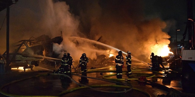 Firefighters work to put out a Seattle marina fire.