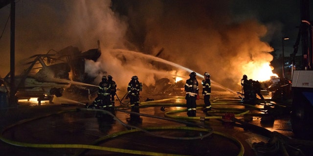 Firefighters work to put out a Seattle marina fire.