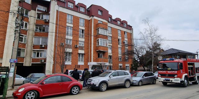 People look at a residential building after a response team extinguished an apartment fire in Novi Pazar, Serbia, March 5, 2023. 