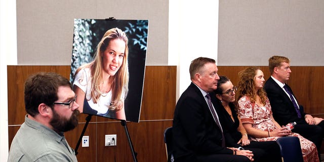 People sit in front of a poster of Kristin Smart hours after a jury found Paul Flores guilty in her 1996 murder on Oct. 18, 2022, in Salinas, California.