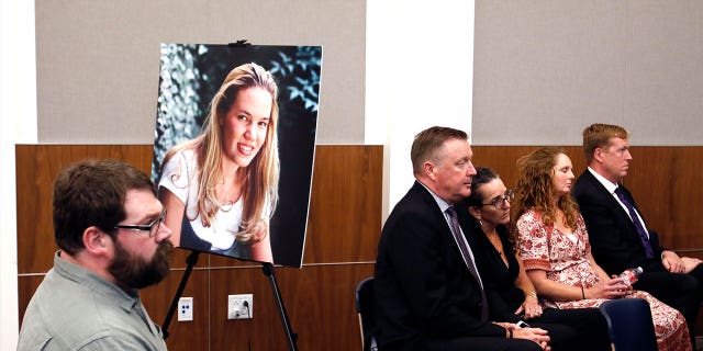 People sit in front of a poster of Kristin Smart hours after a jury found Paul Flores guilty in her 1996 murder on Oct. 18, 2022, in Salinas, California.