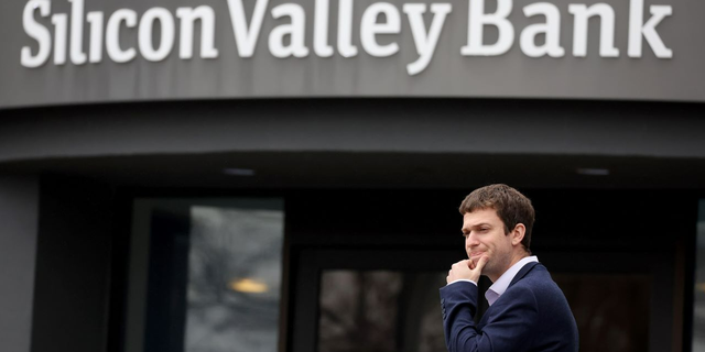 A customer stands outside a shuttered Silicon Valley Bank (SVB) headquarters on March 10, 2023 in Santa Clara, California.