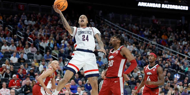 Jordan Hawkins #24 of the Connecticut Huskies drives to the basket against Kamani Johnson #20 of the Arkansas Razorbacks during the first half in the Sweet 16 round of the NCAA Men's Basketball Tournament at T-Mobile Arena on March 23, 2023 in Las Vegas, Nevada.