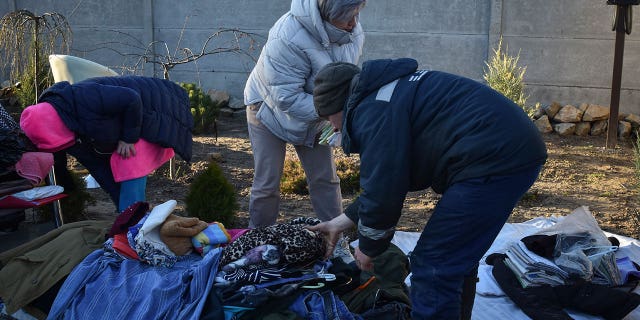 Ukrainians collect their belongings from a building destroyed by Russian bombs on March 31, 2023.