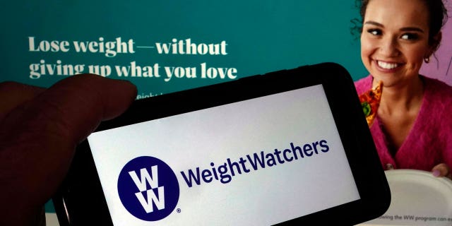 This image shows the logo of WeightWatchers on a mobile phone, and the company's website, in New York, on March 7, 2023.